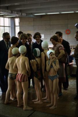 Iona Campagnolo standing with unknown adults and young swimmers at an aquatic centre in East Germany