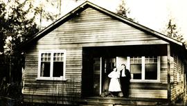 Mr. and Mrs. Collins standing on the porch of their house