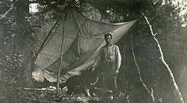 A. H. Holland in camp with dog "Stubs"