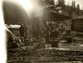 Group of seated soldiers, relaxing with packs nearby