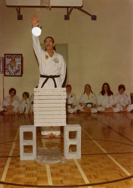 J. Harry Crawshaw standing before cement blocks before karate chop