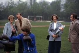 Iona Campagnolo holding flowers and standing behind boxing youth in East Germany