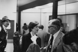 Iona Campagnolo talking to unknown man with Houston Mayor Basil Studer nearby at the official opening of the Houston & District Curling Club
