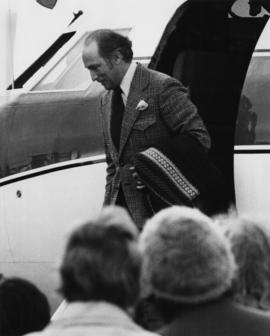 Prime Minister Pierre Trudeau disembarking from airplane as crowds watch