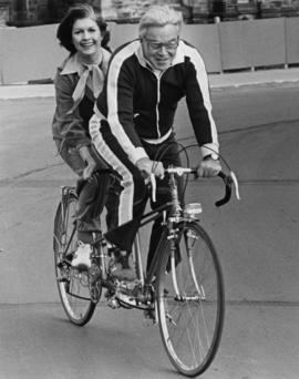 Iona Campagnolo riding a tandem bicycle with an unidentified man