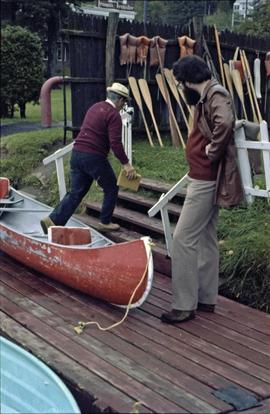 Iona Campagnolo's assistant watches an unidentified man get out of a canoe