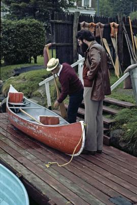Iona Campagnolo's assistant and unidentified man examine a canoe