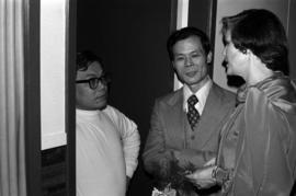 Iona Campagnolo talks with two unidentified men in a doorway