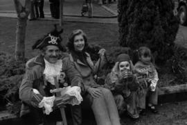 Iona Campagnolo, man in pirate costume, and children sitting on the curb at the Prince Rupert Sea Festival