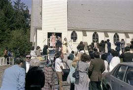 Godfrey and Vicki Kelly on church steps with crowd at 50th wedding anniversary celebration in Masset