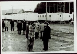 Group of thirteen unidentified men gathered in front of portable buildings at the sodturning ceremony for the opening of the Prince Rupert Fairview Terminal