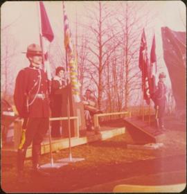 M.P. Iona Campagnolo speaks at Douglas Day, flanked by two RCMP, two Canadian and two British Columbian flags