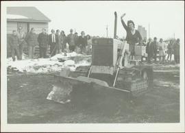 M.P. Iona Campagnolo waves from tractor in front of unidentified crowd