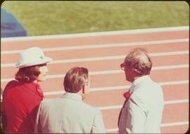 Minister Iona Campagnolo speaking to unidentified man and Prime Minister Pierre Trudeau, 1976 Summer Olympic Games