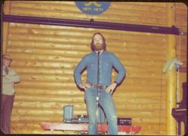 Unidentified man on stage during tour to bring television access from Yukon to Atlin, 1977