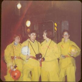 Minister Iona Campagnolo with Mary Schindel and two unidentified women; all wear yellow safety suits, Granduc Copper Mine, Stewart, BC