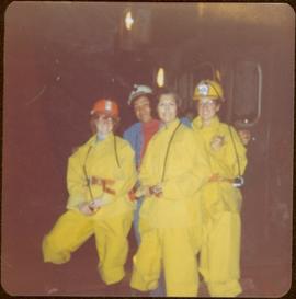 Minister Iona Campagnolo with Mary Schindel, John Lundquist, and an unidentified woman; all but Lundquist wear yellow safety suits, Granduc Copper Mine, Stewart, summer 1977