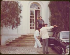 Ministry of Sport Tour - Ian Howard, Frances Pilfold, Chuck Pilfold, and Eric Morse walk down front steps of State Guest House to a waiting car, Havana, Cuba