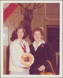 Minister Iona Campagnolo holding ornamental plate next to Bunne Hoffman, editor of the Chetwynd Echo, Chetwynd, BC