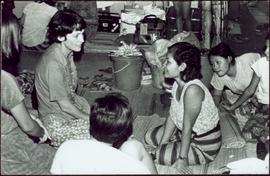 CUSO Mission, North-eastern Thailand - Unidentified woman kneels on floor with young girls