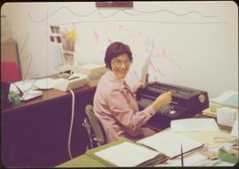 Alice Massad typing at her desk in the Ottawa office