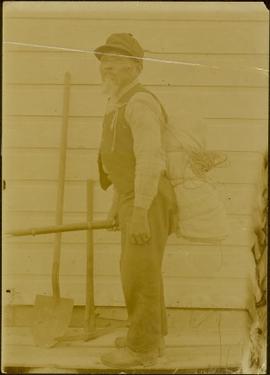 Arthur Wellington Clah carrying bundle and gun