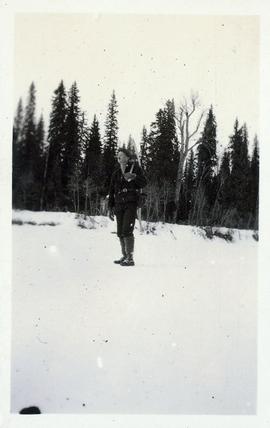 Man holding snowshoes on his back while standing on the snow