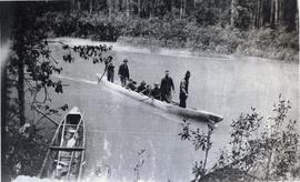 Several men in a canoe about to reach shore