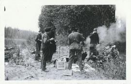 Several men standing around a fire