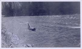 A man steering a canoe through rapids