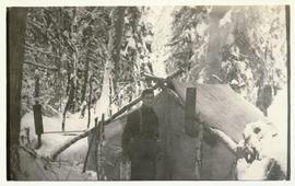 Man standing in front of a tent with a stovepipe