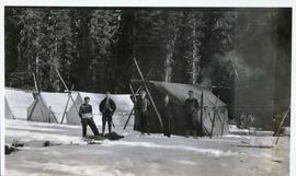 Five men standing in front of a tent