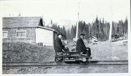 Two men sitting on a rail cart