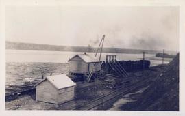 A sawmill with several logs in the water