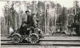 Two men riding on a rail handcar