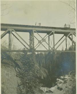 Railroad surveyors on top of an expansive railway bridge