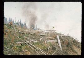 Woods Division - Fire - Helicopter hovering over hillside with fire ignition device
