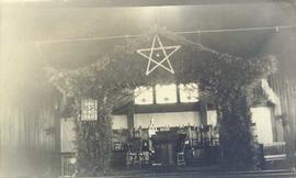 A church interior decorated with tree boughs and a star