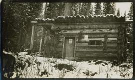 A man standing in front of a cabin
