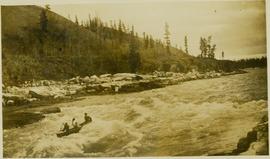 Three men in a canoe going down river rapids