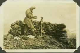 Frank Swannell surveying on top of Mt. McConachie