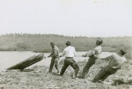 Four men pulling a raft out of Kitchner Lake