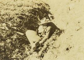 Prentiss Gray sitting next to his second big horn sheep within a dry creek bed