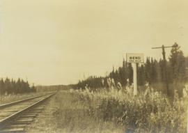 "Bend one mile" sign posted next to a railway track