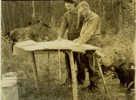 Bob Potts and HG Dimsdale reading maps on a makeshift table 