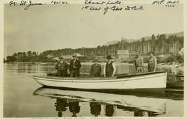 Harry Perry standing with five other men in a row boat on Stuart Lake in Fort St. James, BC