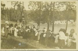 People sitting at a long row of picnic tables at a Liberal Party picnic