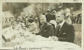 Hon. W. Sutherland and Alex Manson sit at a picnic table at a Liberal Party picnic