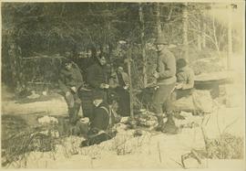Six unidentified men taking a break at a winter campsite