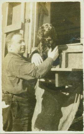 Unidentified man holding a black dog